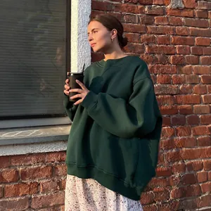 Women's oversized dark green crewneck sweatshirt for a trendy autumn street style look.