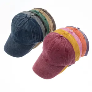 Detailansicht mehrerer farbiger gewaschener Baumwoll-Basecaps mit Distressed-Textur.
