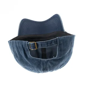 Detailansicht der verstellbaren Metallschnalle an einer blau gewaschenen Denim-Kappe.