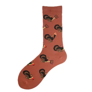 Burnt orange crew socks featuring funny turkey and pitchfork pattern for Thanksgiving holiday