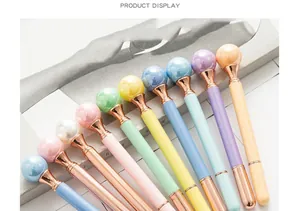 Close-up detail of creative metal ballpoint pens with decorative pearl tops in candy colors.