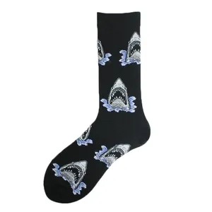 Close-up detail of black crew socks featuring repeating funny shark head and blue wave patterns