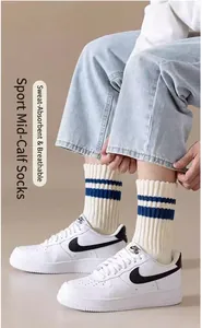 Dettaglio di calze a costine in cotone bianco con strisce blu indossate da un modello uomo