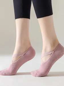 Close-up of pink non-slip yoga socks with cross straps for Pilates exercise