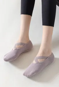 Detail shot of purple non-slip yoga socks featuring an elegant cross strap design