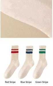 Dettaglio di calze color crema con strisce rosse blu e verdi per un look sportivo retrò