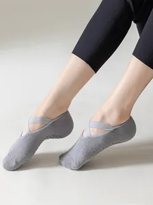 Detail view of grey yoga socks featuring cross-strap design and anti-slip silicone dots.
