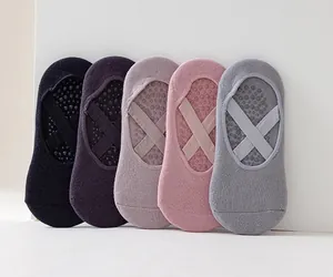 Five pairs of non-slip yoga socks with criss-cross straps in various muted colors.