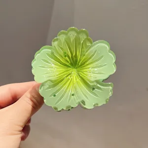 Close-up of green gradient hibiscus flower hair claw clip with translucent finish