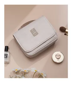 High-angle shot of a beige waterproof hanging toiletry bag with cosmetic props.