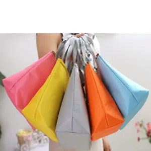 Colección vibrante de bolsas térmicas de colores sostenidas juntas en una sola mano