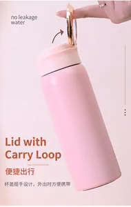 Detail of pink vacuum insulated thermos featuring a gold-toned metal carry loop lid