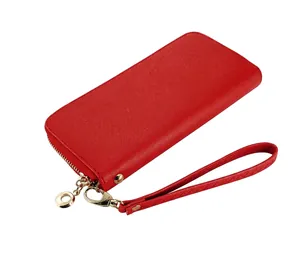 Detalle de una cartera larga de cuero PU rojo con cremallera dorada y correa de muñeca.