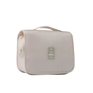 Portable beige waterproof travel toiletry bag with handle and large capacity storage.