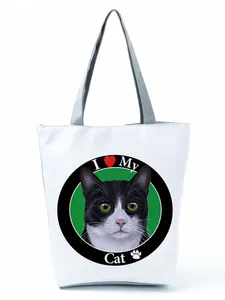 Detail view of white tote bag featuring a cute black and white tuxedo cat print
