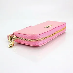 Vista lateral de una cartera larga de cuero PU rosa con un lazo dorado y cierre de cremallera