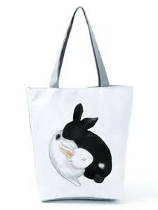 Detailed view of white tote bag featuring a cute black and white bunny illustration.