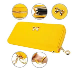 Cartera larga de cuero PU amarillo con detalle de lazo dorado, cremallera y asa de mano