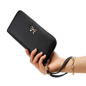Detalle de la cartera larga para mujer hecha de PU negro con un lazo dorado