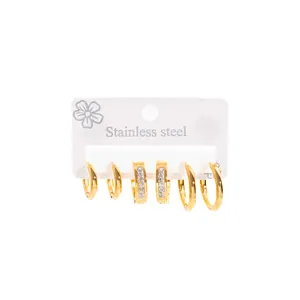 Detailed view of a set of three pairs of gold-toned stainless steel hoop earrings.