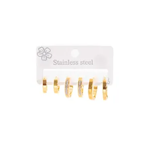 Close-up of gold stainless steel geometric hoop earring set on a display card