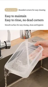 Primer plano de una caja de plástico transparente que se enjuaga bajo un grifo de agua.