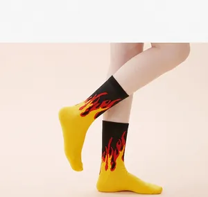 Detailed view of vibrant yellow and black crew socks featuring stylish red flame patterns