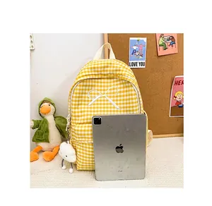 Detailed size comparison of yellow gingham backpack with bow embroidery next to an iPad