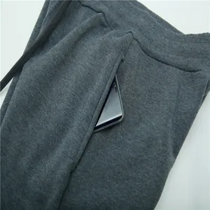 Close-up of deep pocket on dark grey fleece joggers showing fabric texture and phone storage