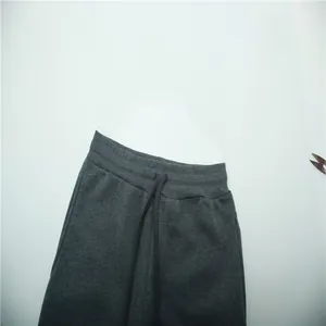 Close-up of charcoal grey fleece sweatpants with elastic waistband and drawstring