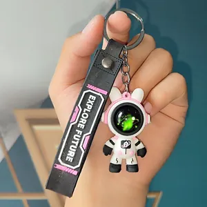 Detailed hand-held view of an astronaut bear keychain with EXPLORE FUTURE black strap
