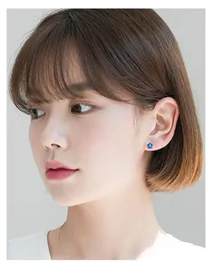Close-up of s925 silver blue flower stud earring worn by Asian model