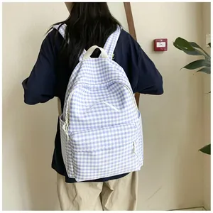 Detail view of stylish blue and white gingham backpack featuring a delicate white bow