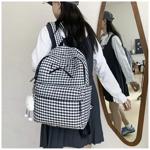 Asian student wearing a black and white gingham backpack with ribbon bow detail