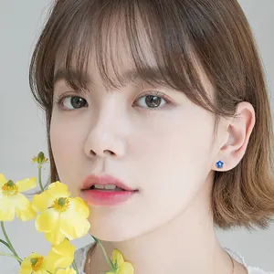 Elegant small s925 silver blue flower stud earring worn by a female model in a close-up