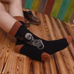 Vintage men's skeleton graphic crew socks with brown accents on a rustic wooden floor