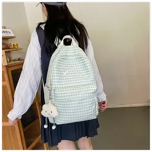 Back view of a student wearing a green gingham backpack with a white bow detail