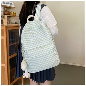 Back view of a girl wearing a fresh green gingham backpack with a white bow detail.