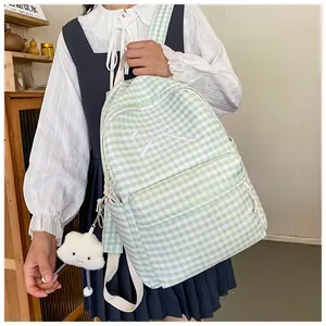 Close-up of green gingham backpack with white bow embroidery and cloud pendant