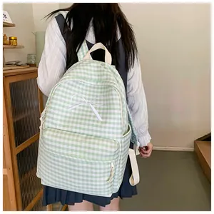 Detail view of a fresh green and white gingham plaid schoolbag with an embroidered white bow
