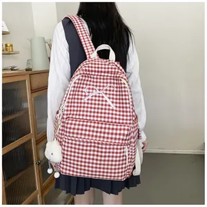 Back view of a red and white checkered backpack with a white bow and cloud charm.