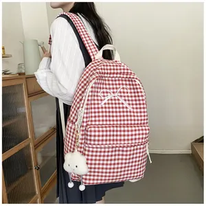 Close-up of a red and white gingham backpack with bow detail worn by a student.
