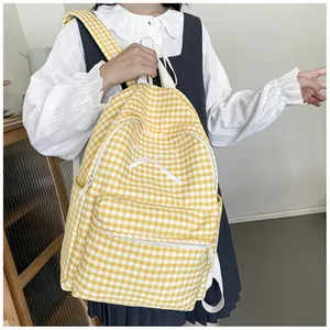 Detailed view of yellow gingham backpack with white bow detail worn by a student