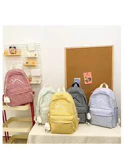 Collection of colorful gingham backpacks with bow details in a lifestyle setting