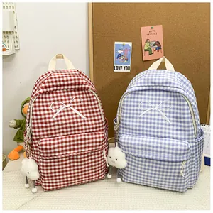 Two plaid canvas backpacks with bow embroidery and cloud charms in red and blue colors