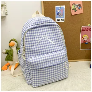 Detailed view of the blue and white checkered backpack with a cute white bow embroidery