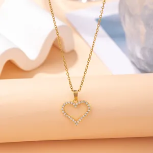 Minimalist gold-plated heart necklace with sparkling crystal inlay on elegant warm background