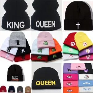Assorted knit beanie caps with various embroidered cartoon characters and text patterns