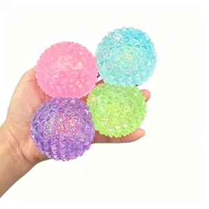 Close-up of four colorful diamond textured squishy stress balls held in a hand
