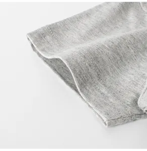 Close-up of the grey cotton fabric and neat stitching on a boys t-shirt sleeve cuff